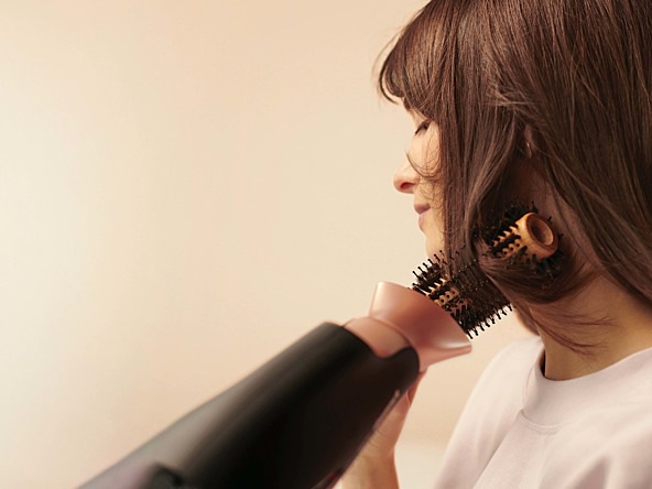photo of woman blow drying her hair with a panasonic product